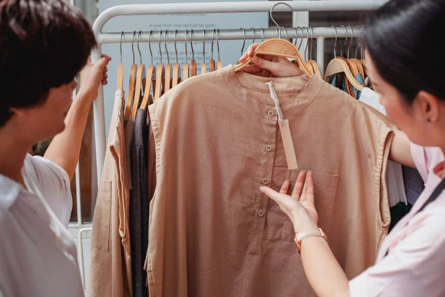 A person looking through a rail of clothes